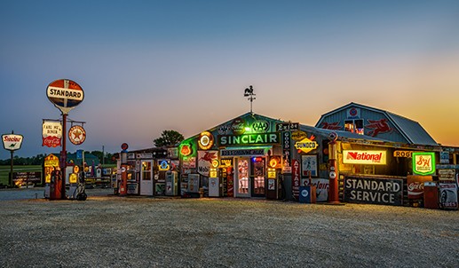 A gas station in the middle of a field at sunset.