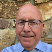 Dale Oglesby in front of a stone wall.