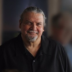 Michael Wallis smiles in front of a group of people.