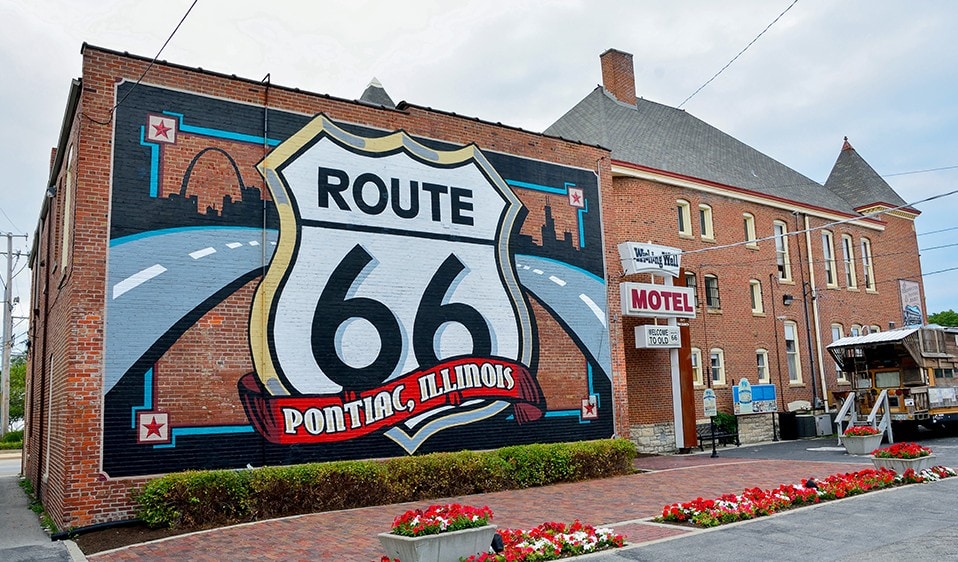 Route 66 is painted on the side of a brick building.